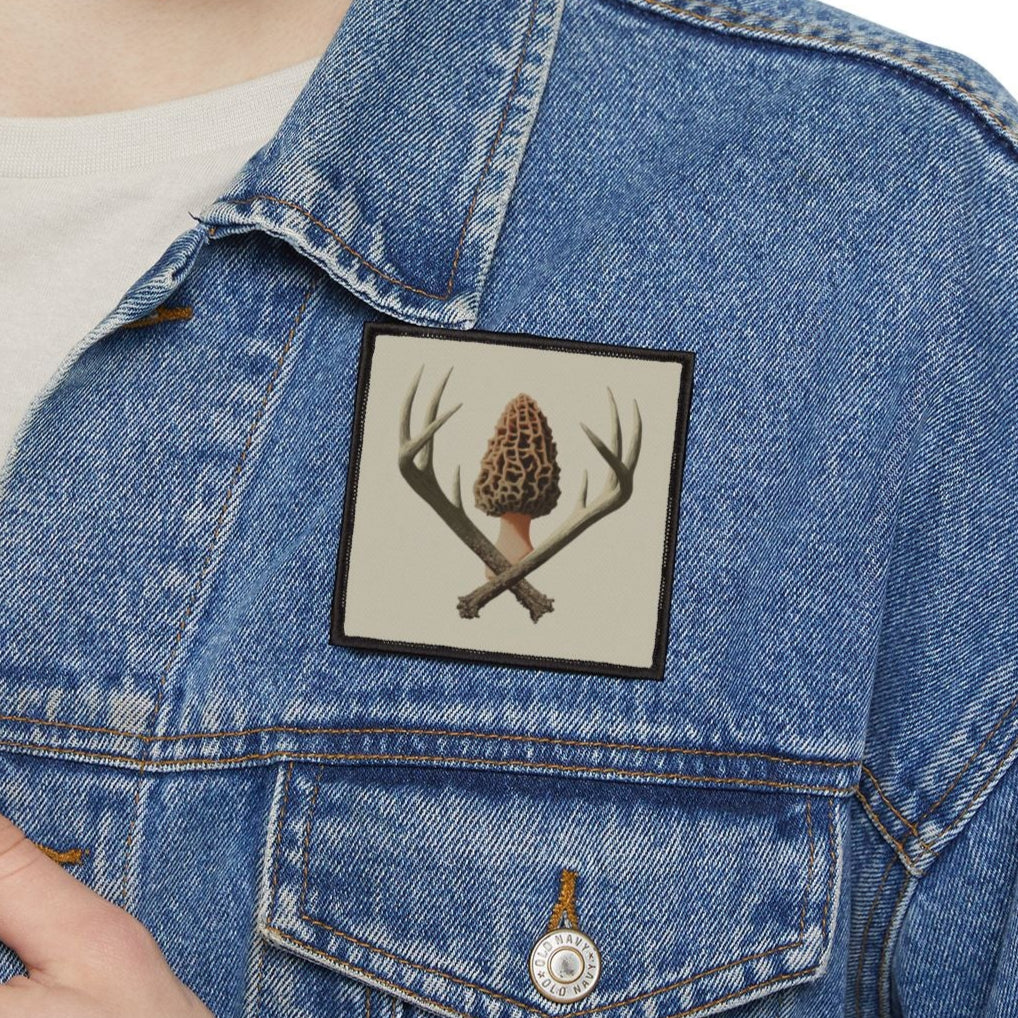 Person wearing a blue denim jacket with a patch on a white background