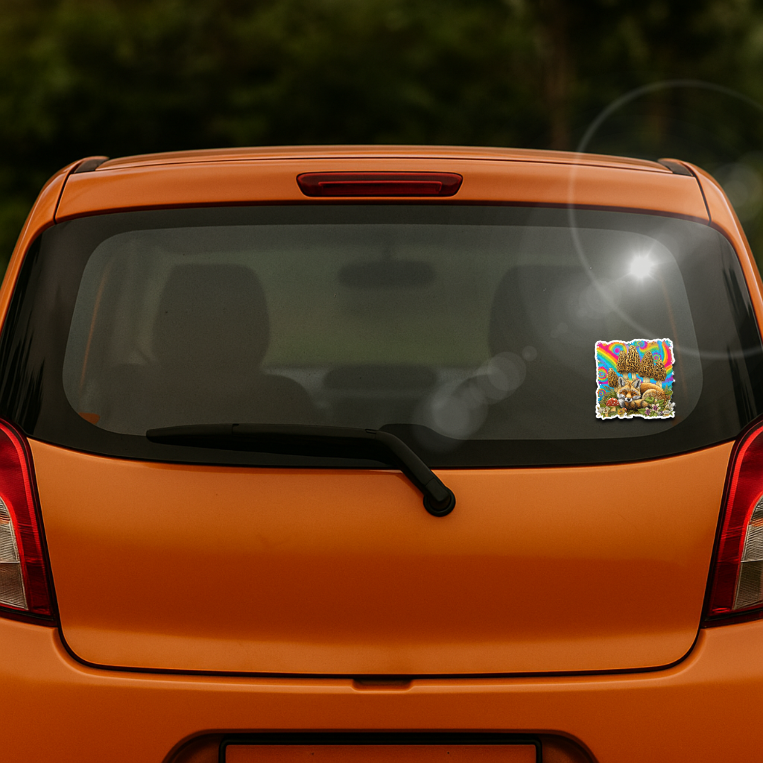 Orange car with a colorful sticker on the rear window, blurred green background