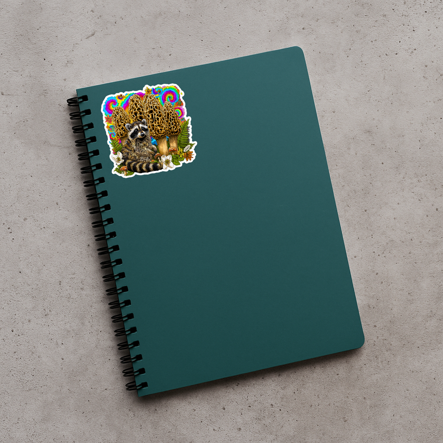 Green notebook with a raccoon sticker on a gray surface