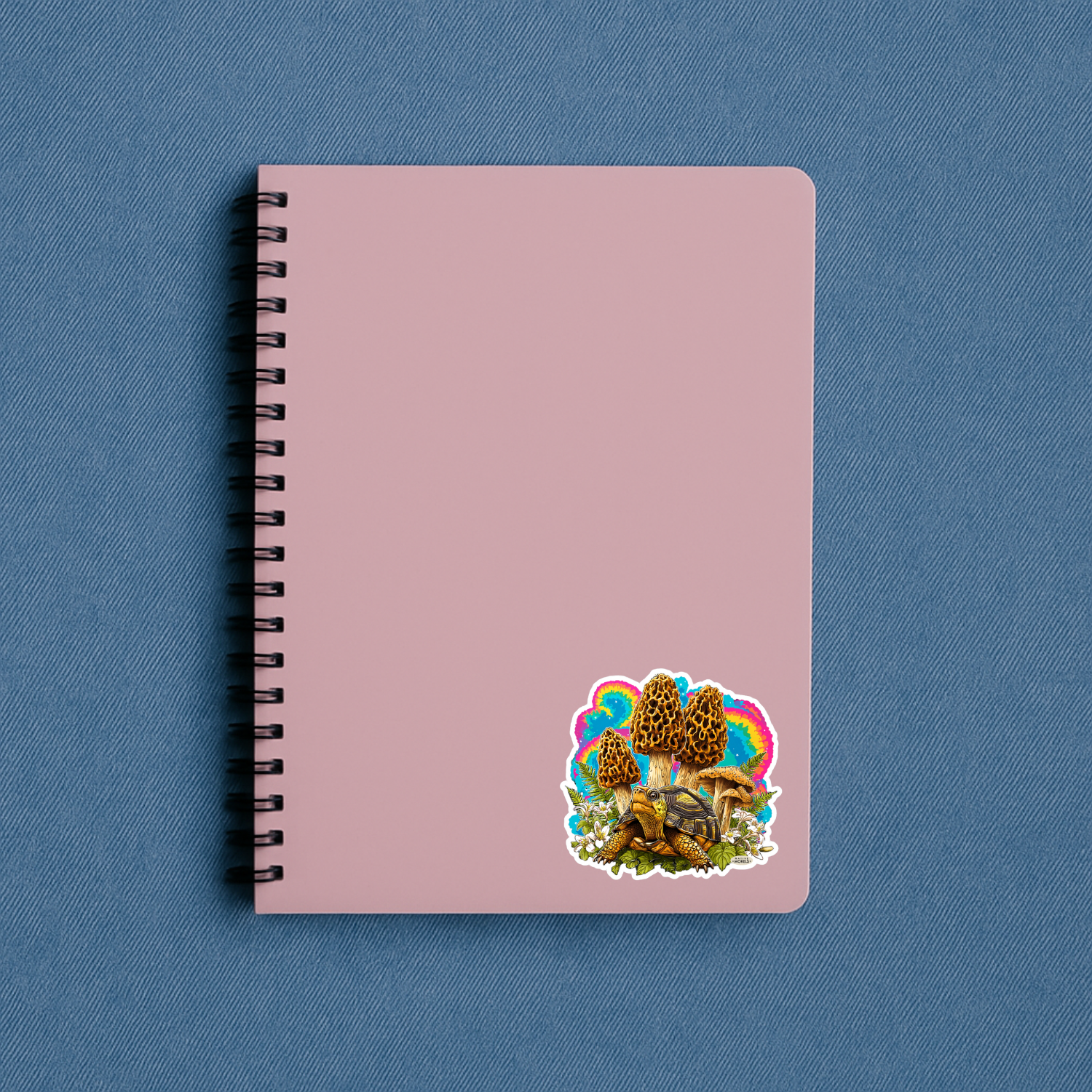 Pink notebook with a colorful sticker on a blue background